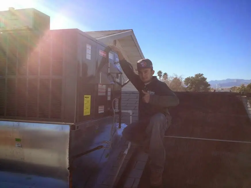 HVAC technician performing Heat Pump Repair on a rooftop unit in Crestwood